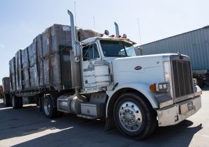 18-wheeler loaded with bundled corrugated packaging.