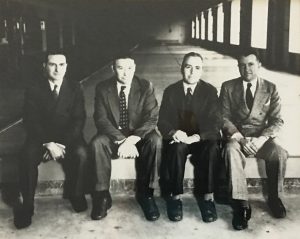 Black & white photo of 4 founders in suits.